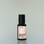 A bottle of Desert Road Eau de Parfum against a grey background.