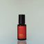 A bottle of Fox Hunt Eau de Parfum against a grey background.