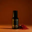 Beardbrand Bold Fortune eau de parfum bottle with saffron threads on a warm orange background representing the fragrance’s rich spice notes.